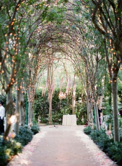 outdoor garden weddings- arched trees with lights form a canopied aisle