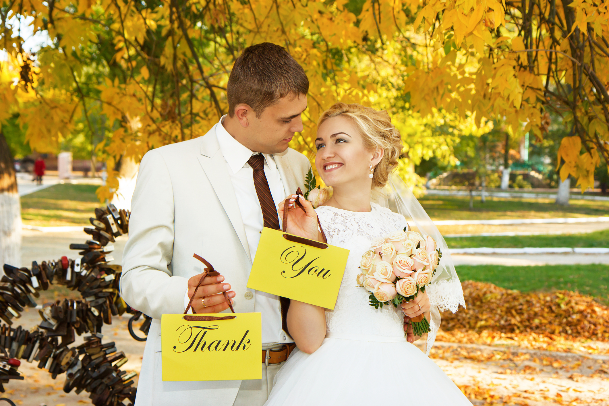 couple holding wedding thank you signs-wedding thank you card wording