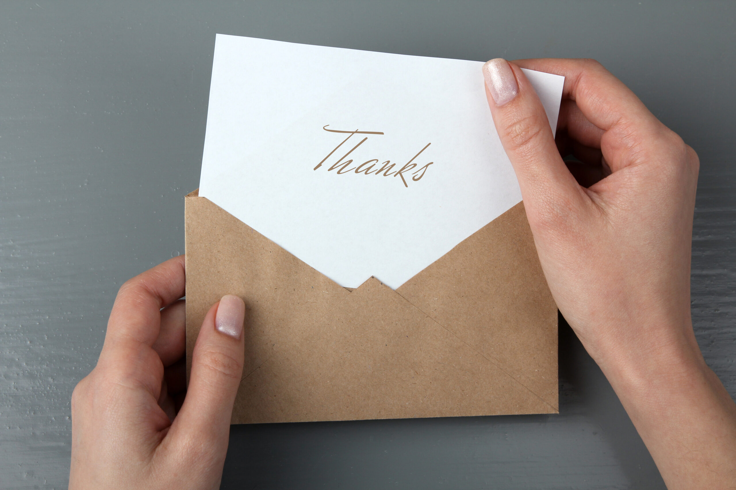 wedding thank you card wording-person pulling thank you card out of envelope